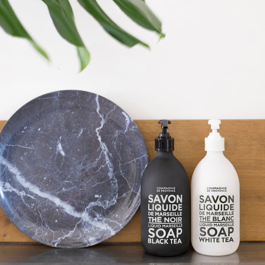 Image of two bath & body lotion bottles along with blue marbled plate