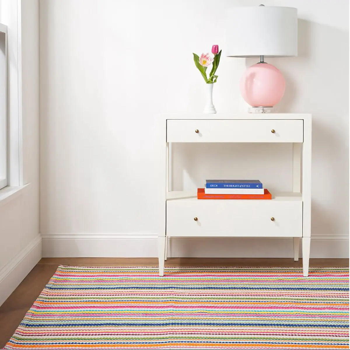 Dash and Albert Summer Stripe Handwoven Indoor Outdoor Rug in a room with a table and lamp