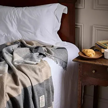 Avoca Rome Cashmere Blend Throw in Beige and Grey on a bed