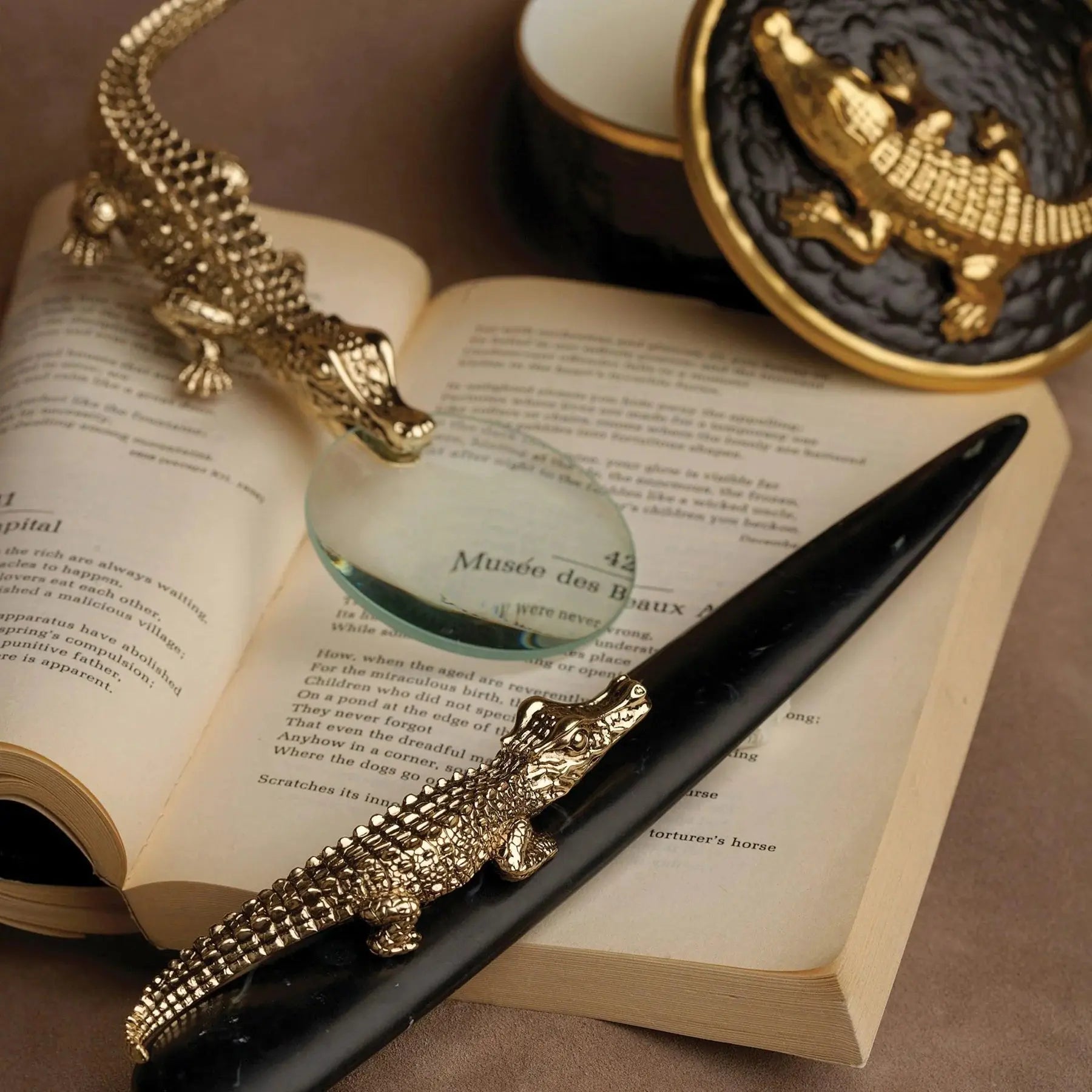 L'Objet Crocodile Letter Opener and Magnifying glass on a book in a room