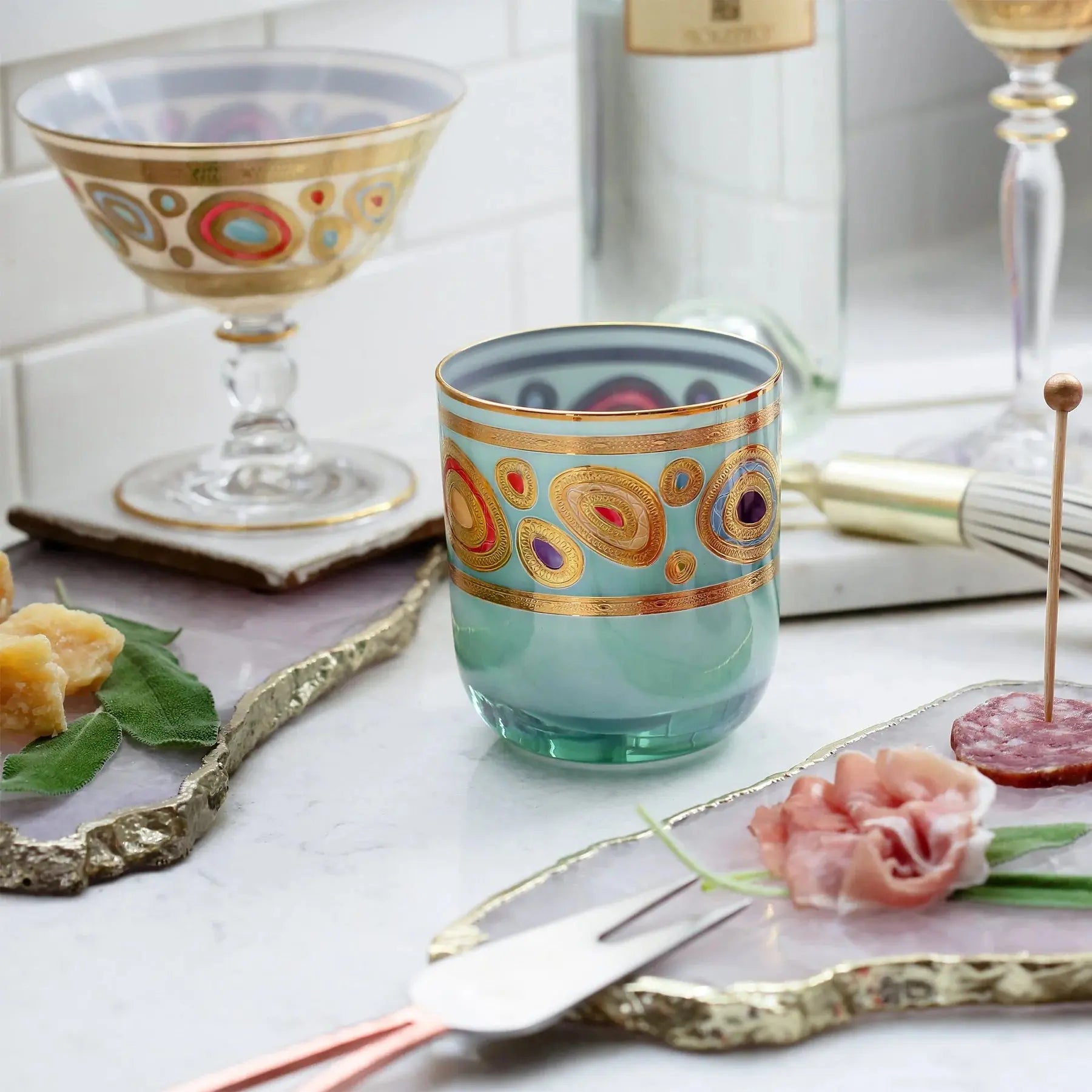 Vietri Regalia Double Old Fashioned Glass in Aqua on a kitchen counter with food and decorative items