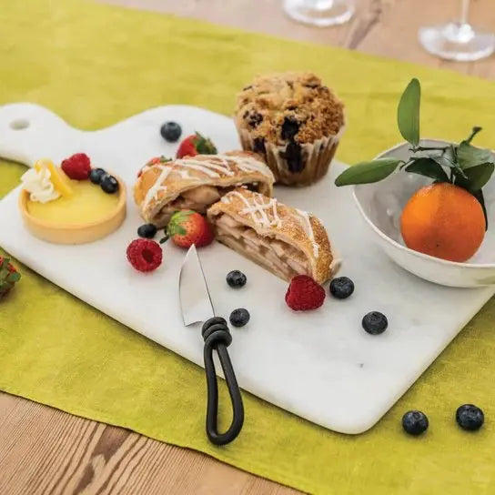 Simon Pearce White Large Marble Board with pastries, berries and an orange with serving knifes set on a table in a room