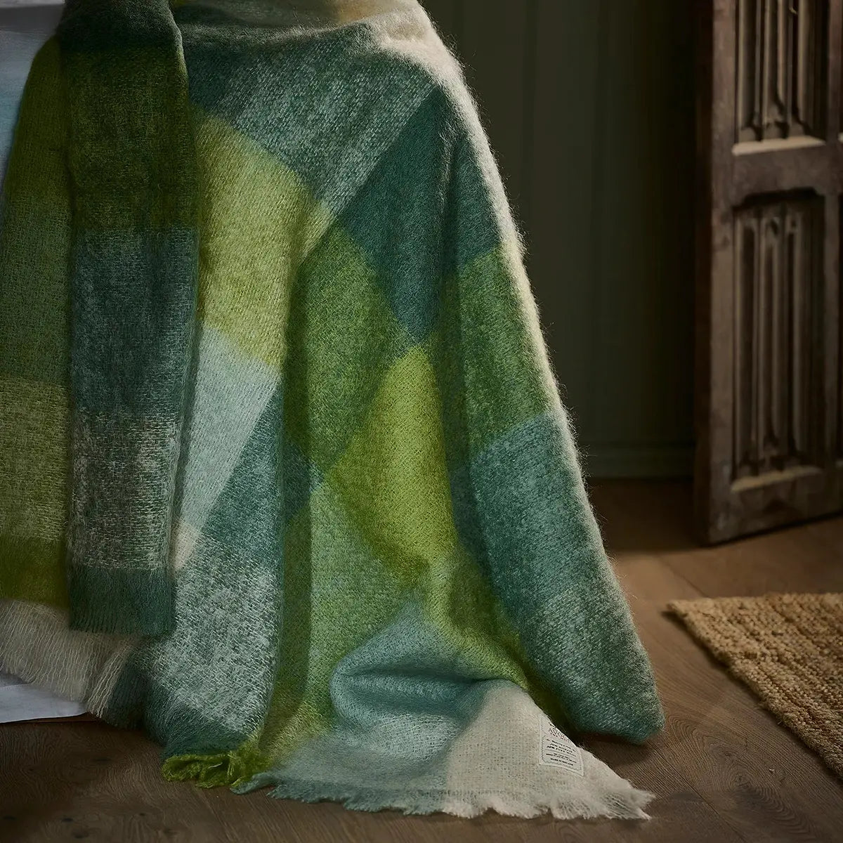Avoca M192 Mohair Throw in Green hung in a room