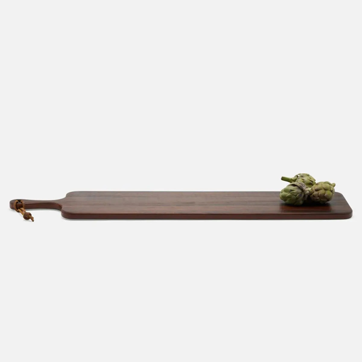 Side view of Blue Pheasant Edmund Natural Walnut Serving Board with three artichokes on top