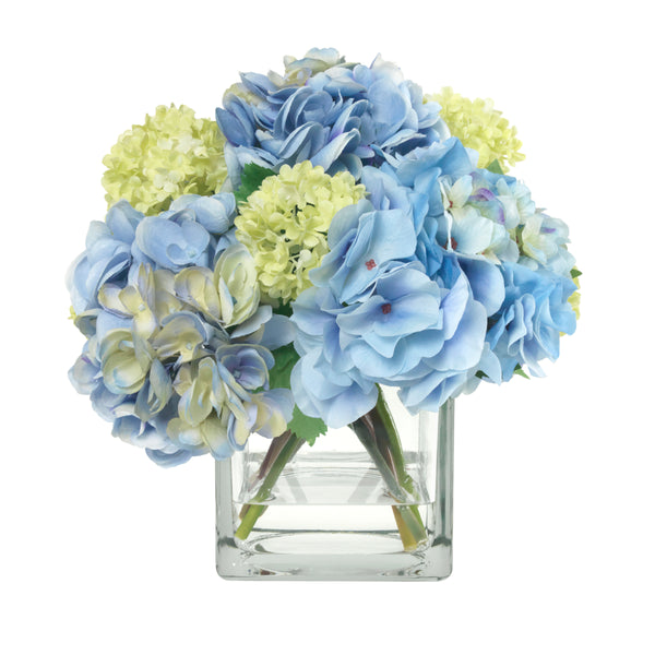An image of Diane James BLOOMS Blue hydrangea and snowball bouquet in glass cube