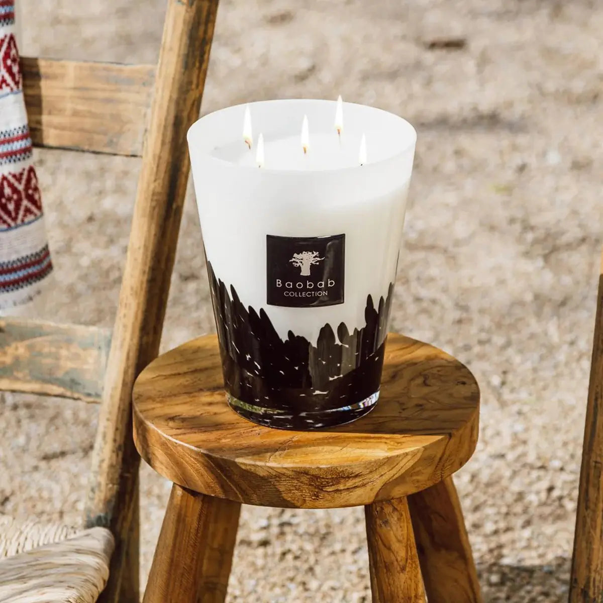 Baobab Collection Max 16 Feathers Candle outside on a stool