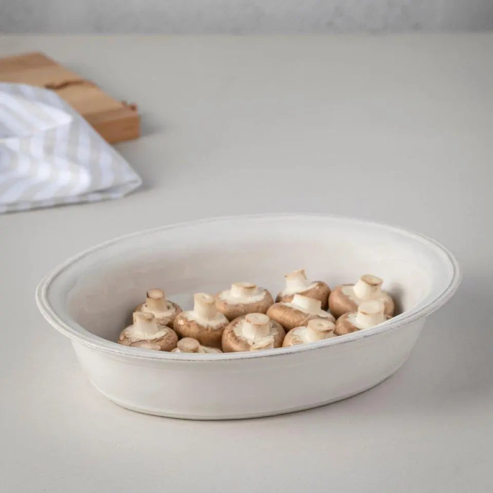Casafina Fontana White 16 inch Oval Baker with mushrooms inside on a table