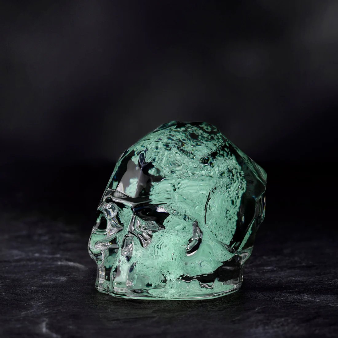 An image of Nude Momento Mori Small Luminous Green Faceted Skull