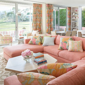 Dash & Albert Capri Soumak Woven Jute Rug in a room with a pink sofa and floral decor
