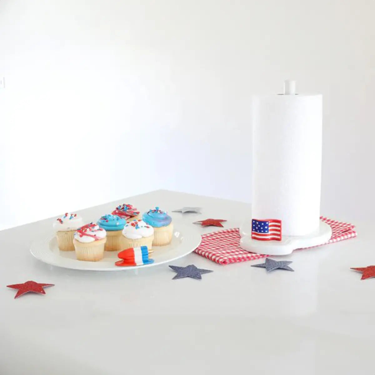 Nora Fleming Stars and Stripes Forever American Flag Mini on a towel holder with confetti stars and cupcakes in a room