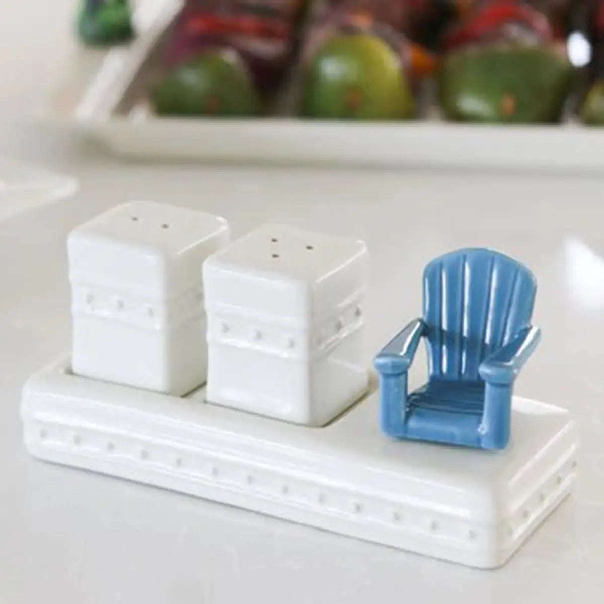Nora Fleming Chillin Chair Adirondack Chair Mini on a salt and pepper shaker in a room with food