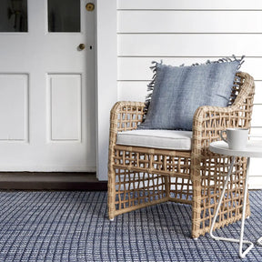 Dash and Albert Coco Blue Handwoven Indoor Outdoor Rug set outside on a front porch