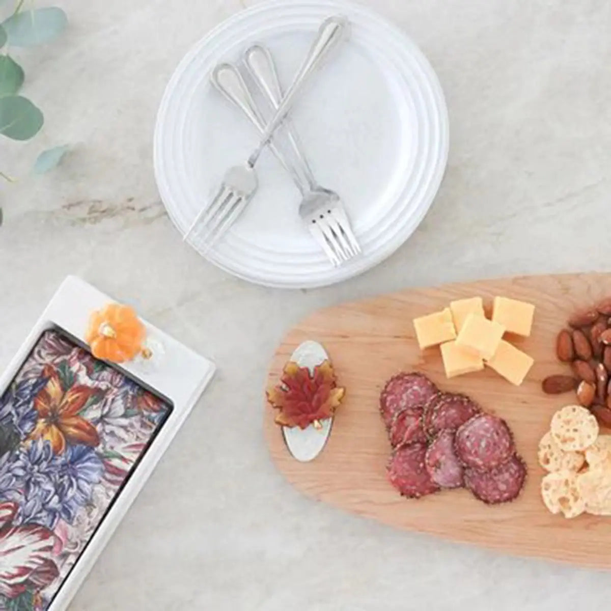 Nora Fleming Maple Tasting Board with food on top with a maple mini in a room with dinnerware