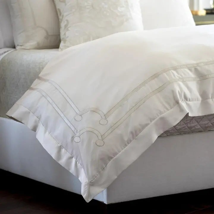 Lili Alessandra Vendome Duvet Cover in Ivory draped on a bed in a room