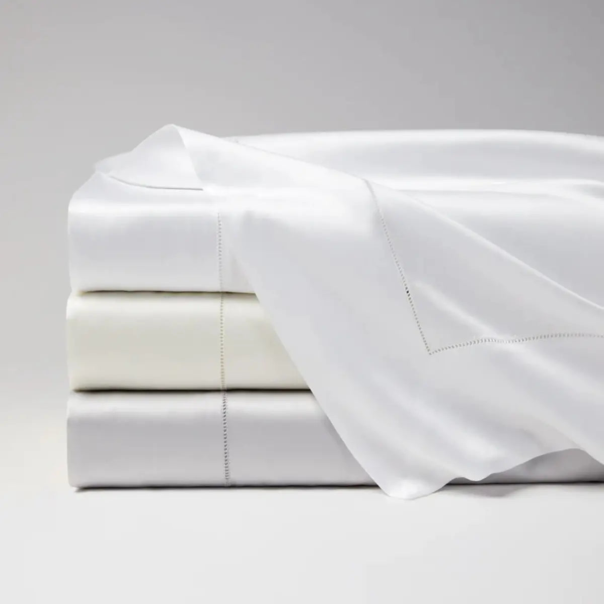 Sferra Giza 45 Sateen Flat Sheets stacked in various colors 