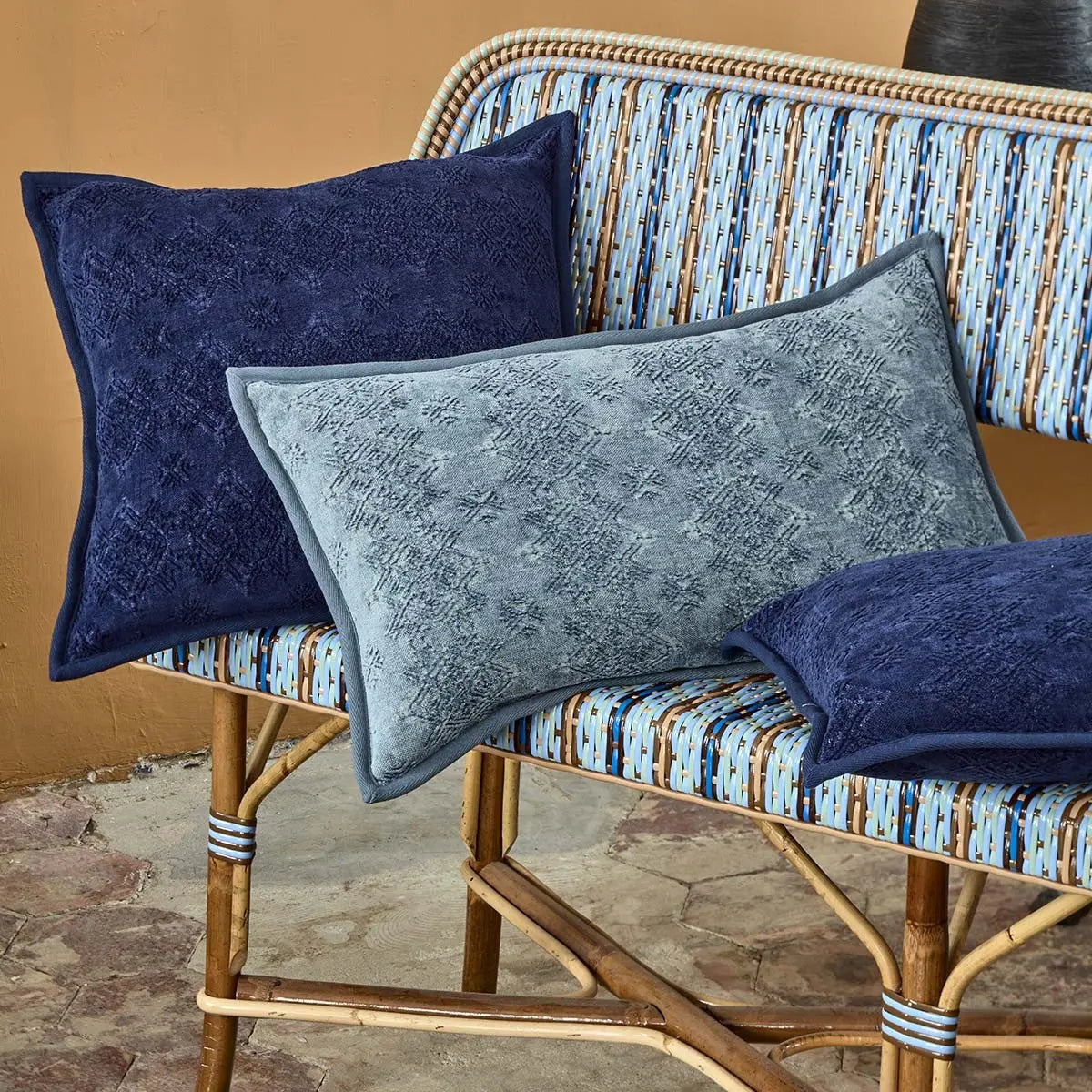 Yves Delorme Syracuse Decorative Pillows in Zinc and Indigo on a bench