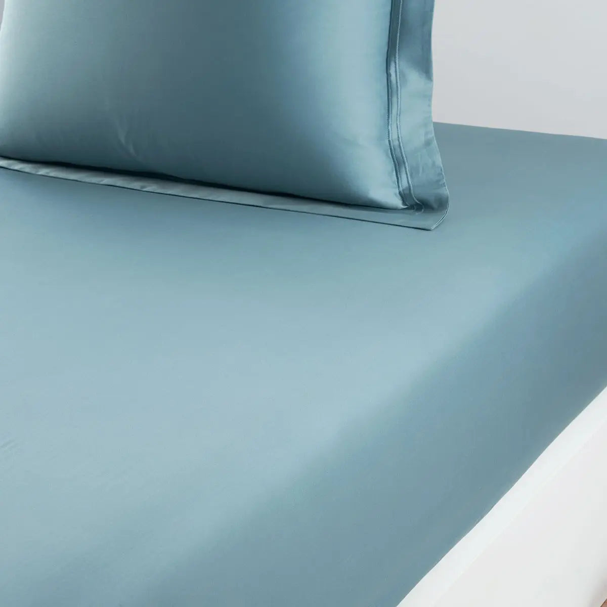 Yves Delorme Triomphe Fitted Sheet in Fjord on a bed