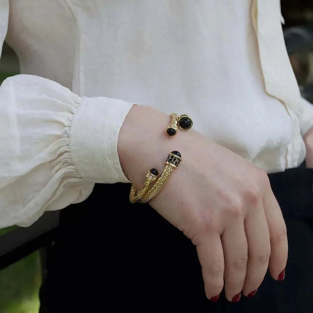 A woman wearing a pair of Halcyon Days Salamander Torque Bangle in Black Gold