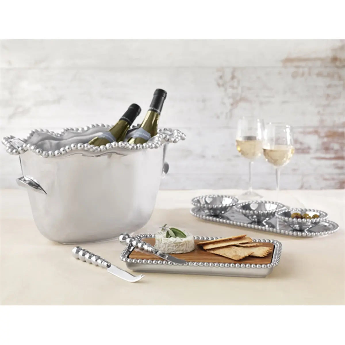 Mariposa Bellini White Wine Glass set on a table with food and ice bucket with white wine