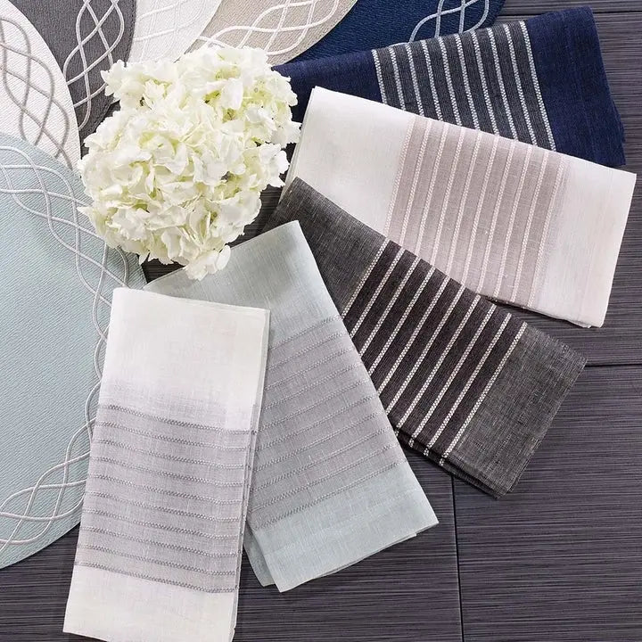 Bodrum Tuxedo Napkin Collection in various colors set on a table with flowers and placemats