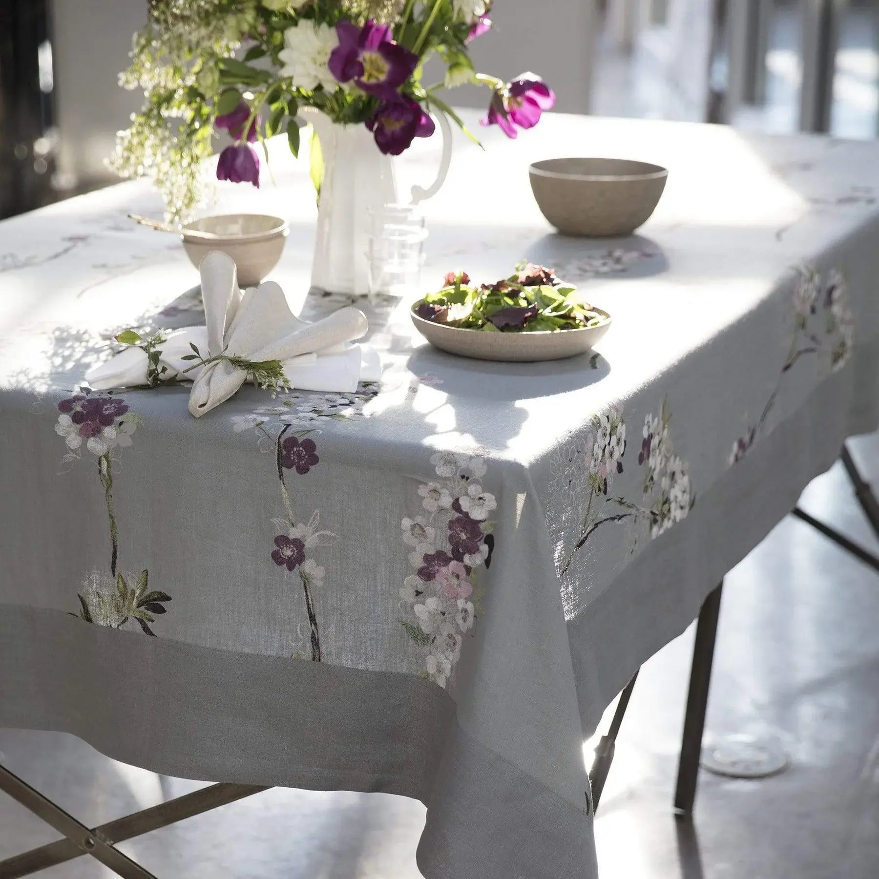 Mode Living Positano Tablecloth on a table with a dinner napkin and salad