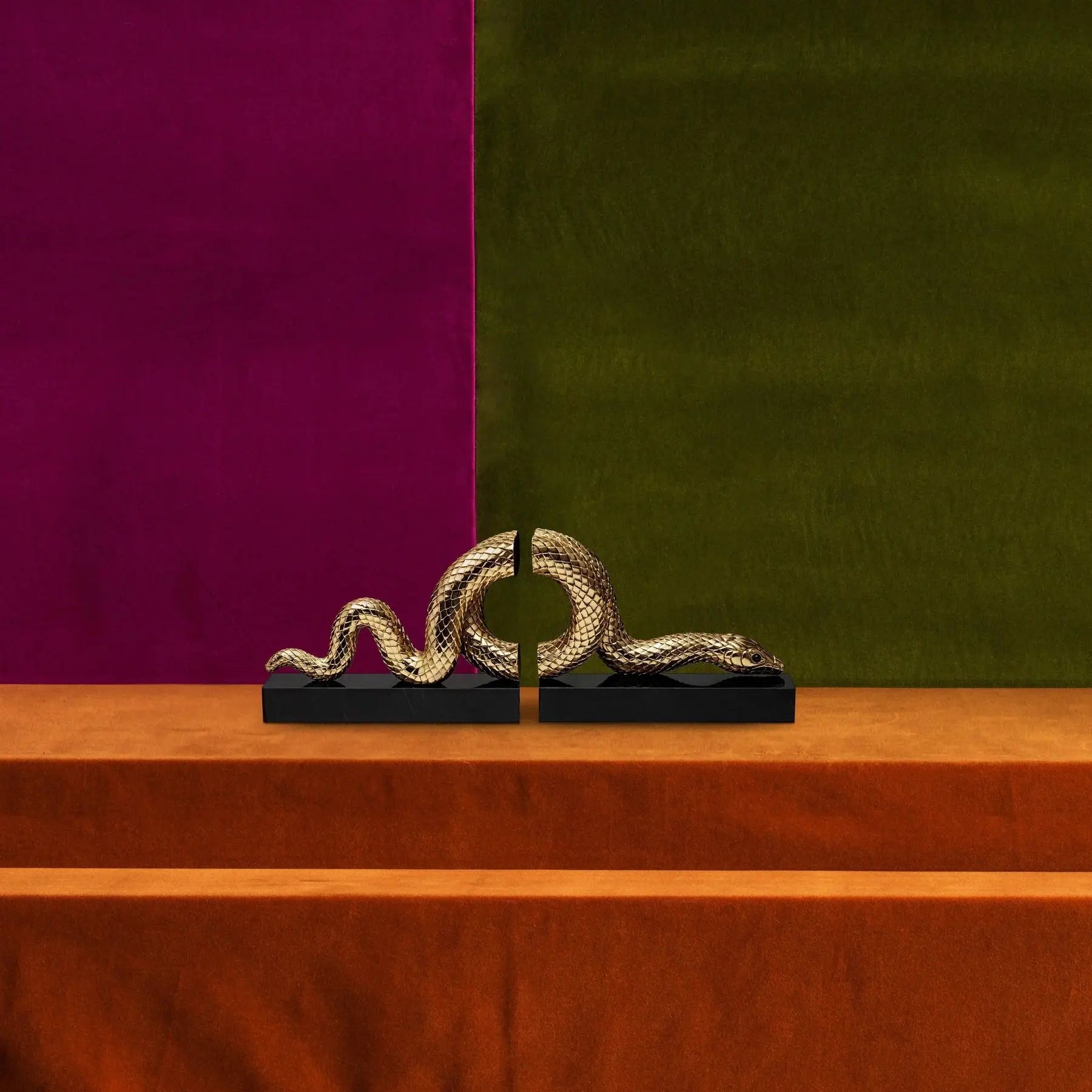 L'Objet Snake Bookend Set in a room with purple and green wall and wooden stairs