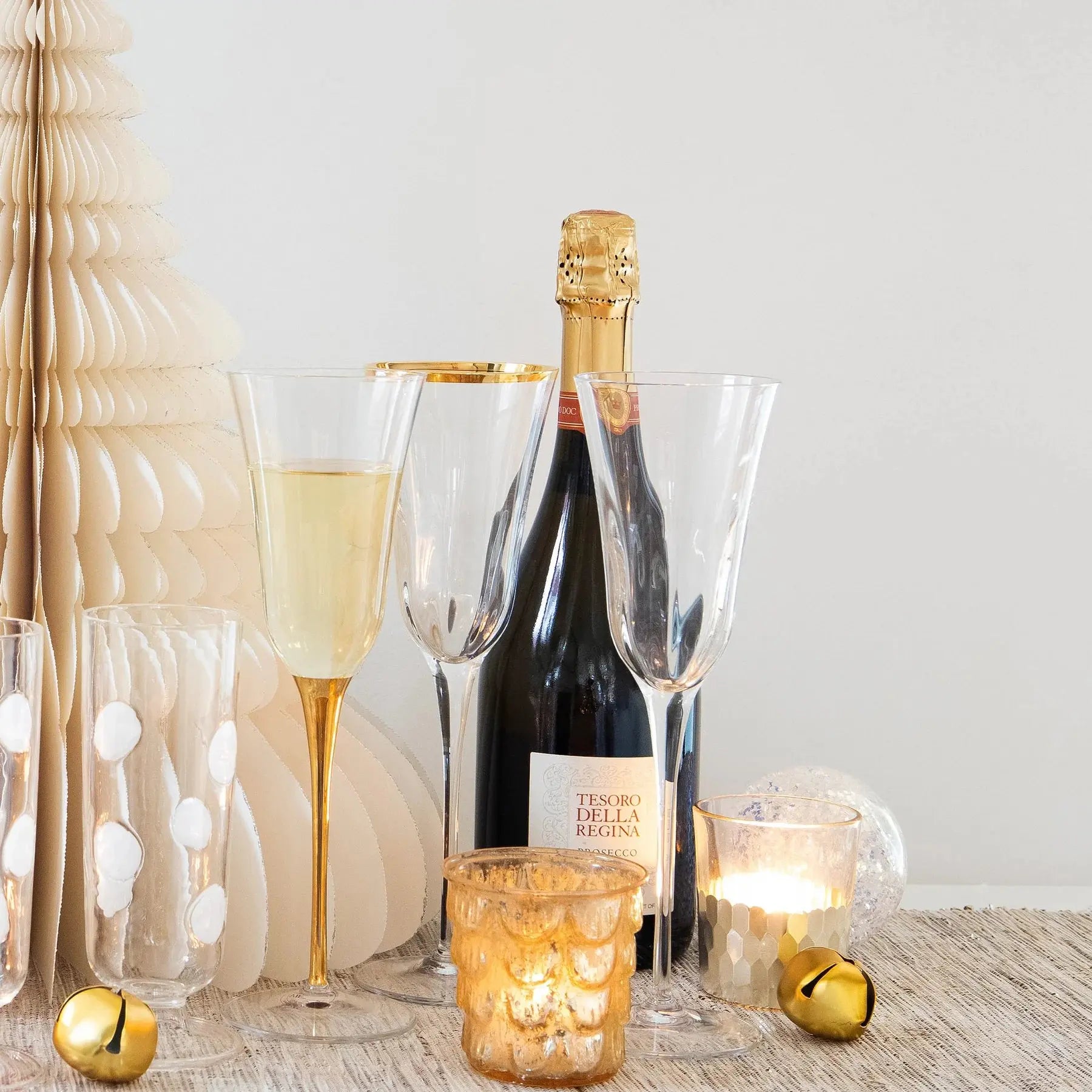 Empty Vietri Optical Champagne Glass set next to other glasses and a champagne bottle on a table