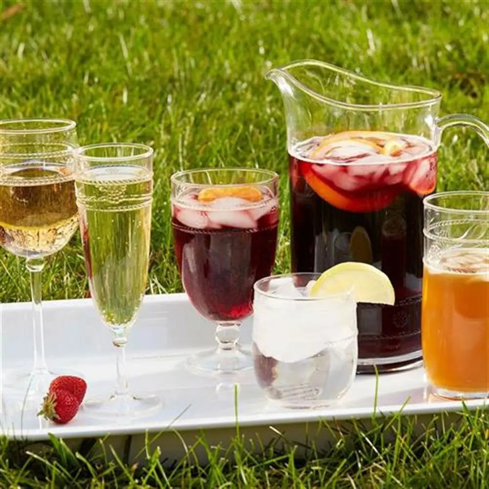 Juliska Isabella Acrylic Goblet filled with ice and juice with a carafe and white tray on the grass