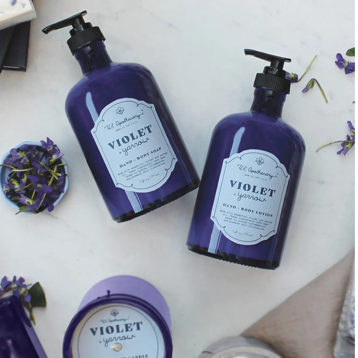 K Hall Studio Violet and Yarrow Apothecary Hand and Body Soap and lotion in a room laid on the floor