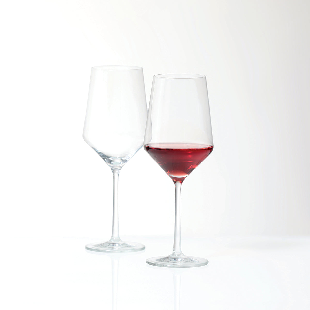 A pair of Fortessa Tritan Pure Cabernet Glass with 1 glass empty, 1 glass filled