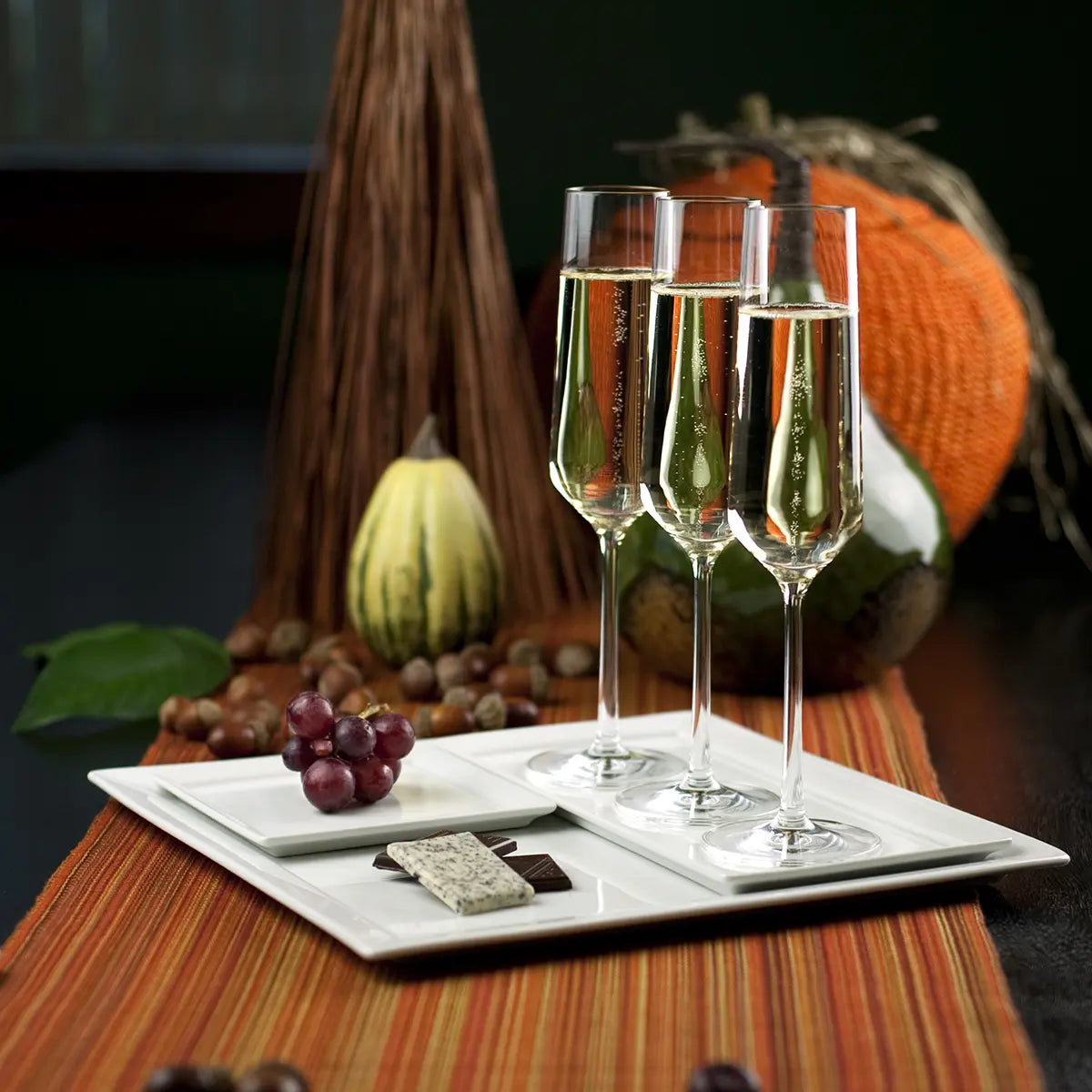 Three Fortessa Tritan Pure Champagne Flute filled and set on tray with food and with other decor items