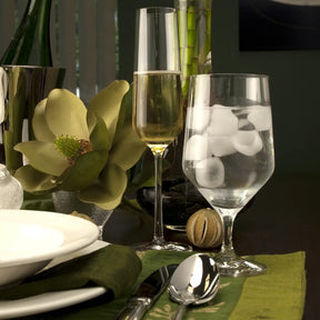 Filled Fortessa Tritan Pure Beverage Water Glass on a table with tableware and other decorative items