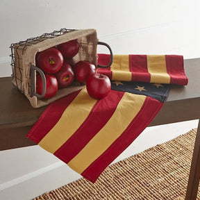 K and K Interiors Red Apple on a wood bench in a room, laid in a rectangular wire basket with an american flag