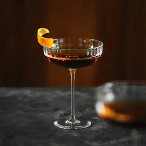 A filled Richard Brendon Fluted Large Coupe with an orange slice
