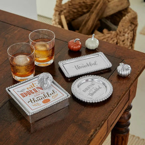 filled Mariposa Bellini DOF Glass on a table in a room with the beaded napkin holder