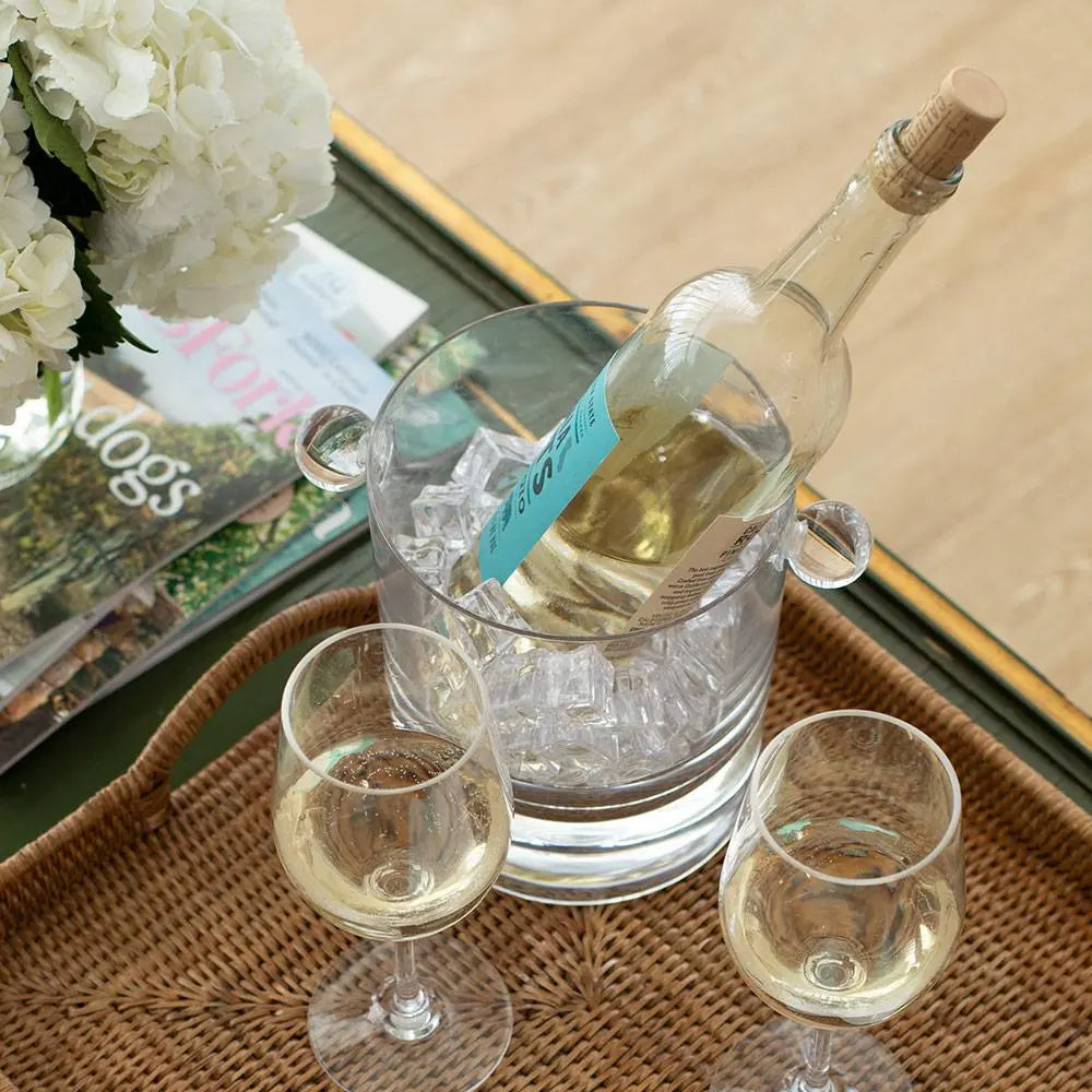  Caspari Crystal Clear Acrylic Ice Bucket and Lid  outside on a table with a champagne bottle inside with other glassware