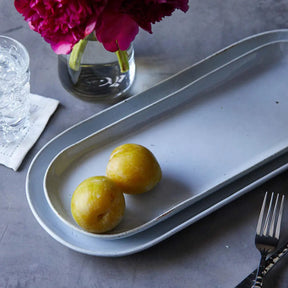 Blue Pheasant Marcus White Salt Glaze Oblong large Serving Platter on a table with food and flatware and a glass