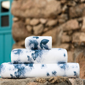 Stack of Graccioza Bella Towels set outdoors on a rock
