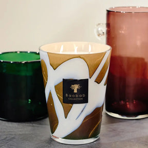 Baobab Collection Max 16 Stones Agate Candle on a table set next to a green and burgandy glass cylinder