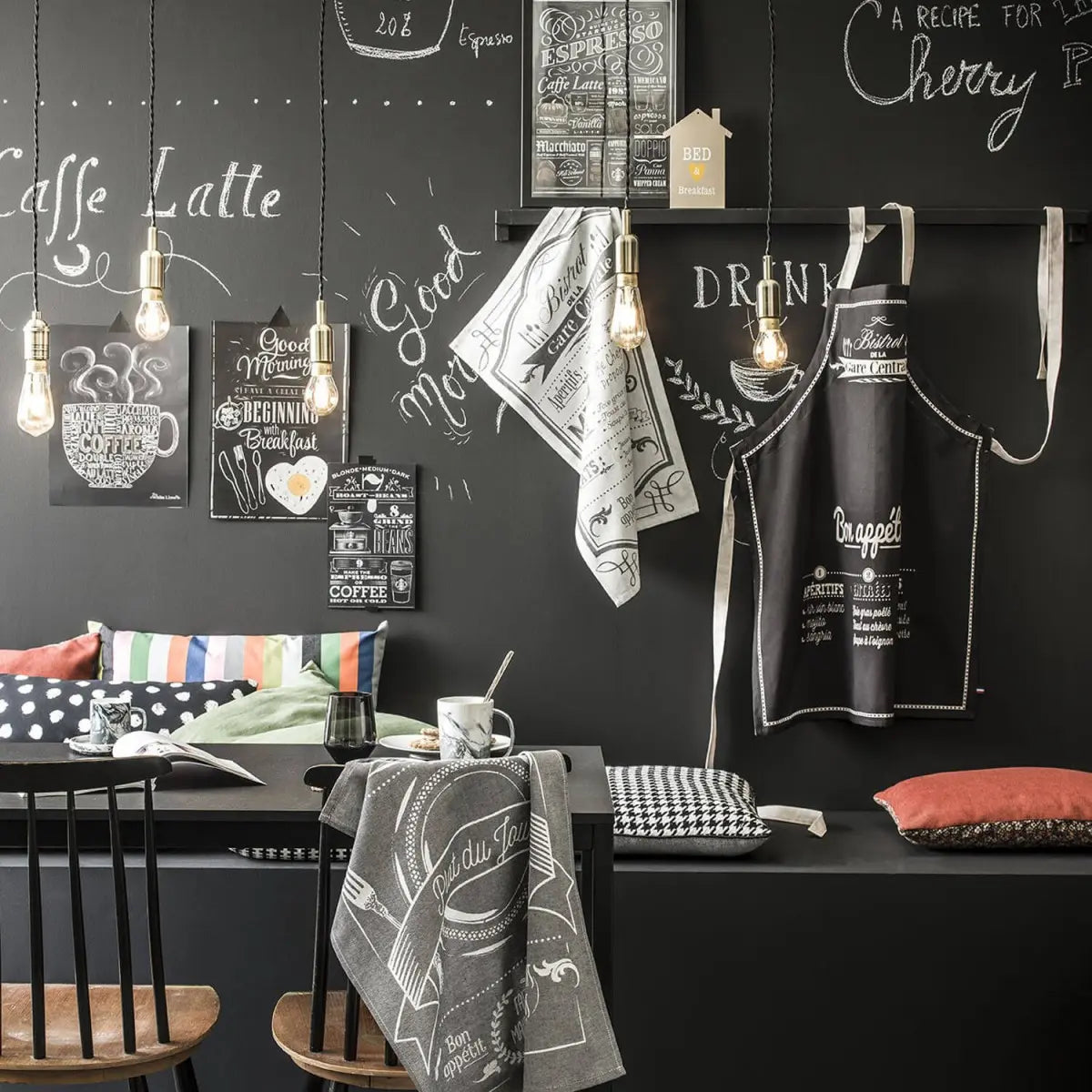 Coucke Au Menu Jacquard Kitchen Towel hung in a room with a chalk board wall and furniture .