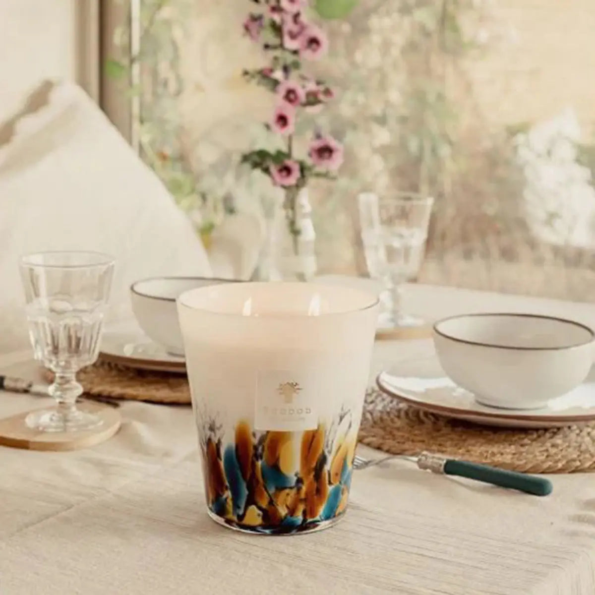 Baobab Collection Max 24 Rainfoest Mayumbe Candle set on a dining table with dinnerware and flowers in a vase