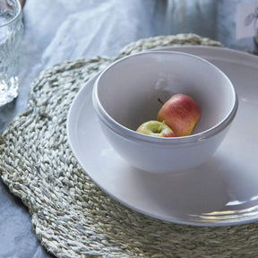 Blue Pheasant Vera Mixed Gray Flower Placemat with a bowl and plate with fruit in a room