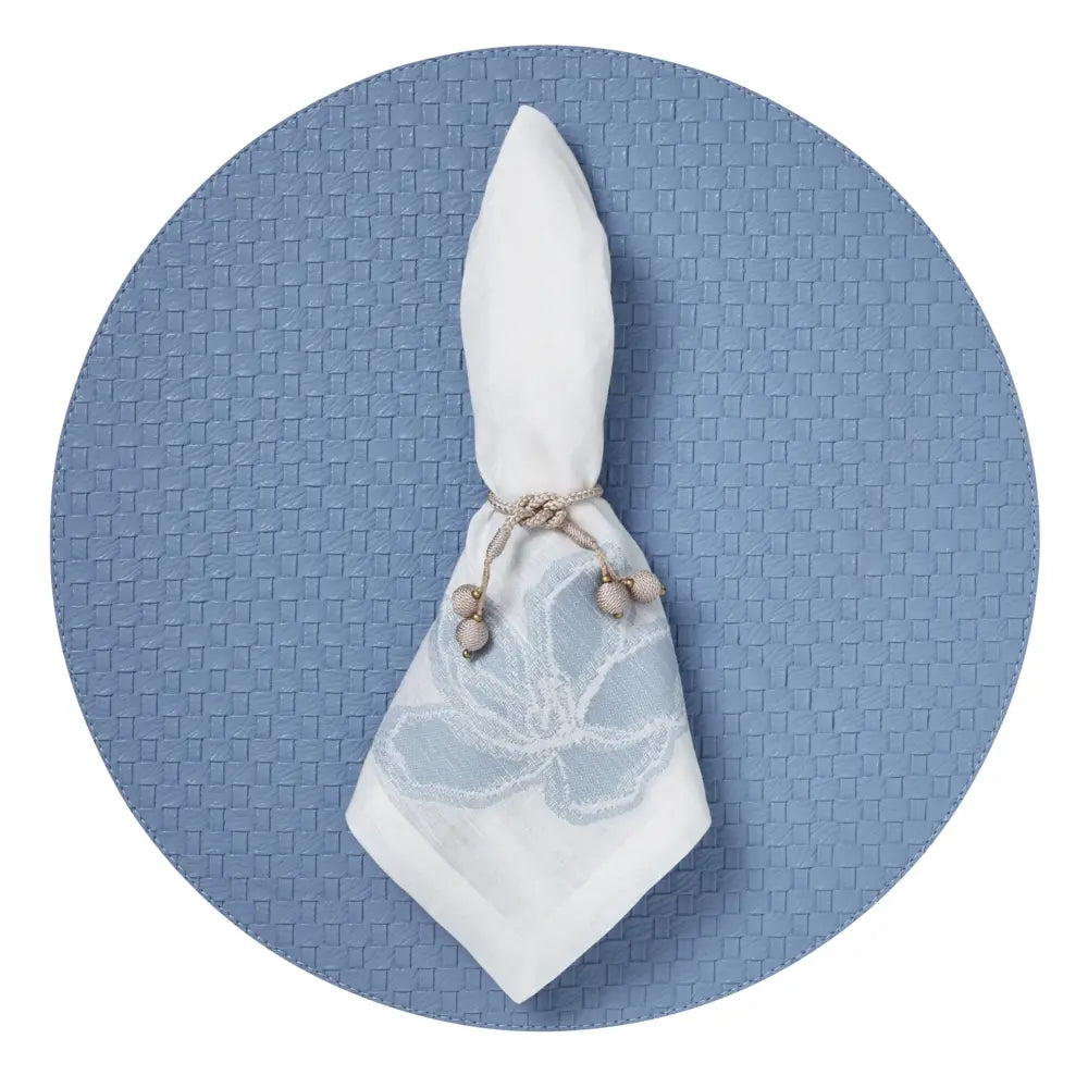 Mode Living Malibu Napkin with a napkin ring on a blue placemat