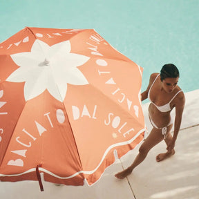 Sunnylife Beach Umbrella Baciato Dal Sole at the beach with a woman