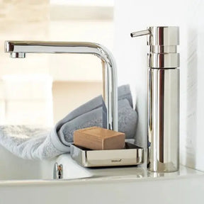 Blomus NEXIO Soap Dispenser by a sink with a grey towel and soap dish