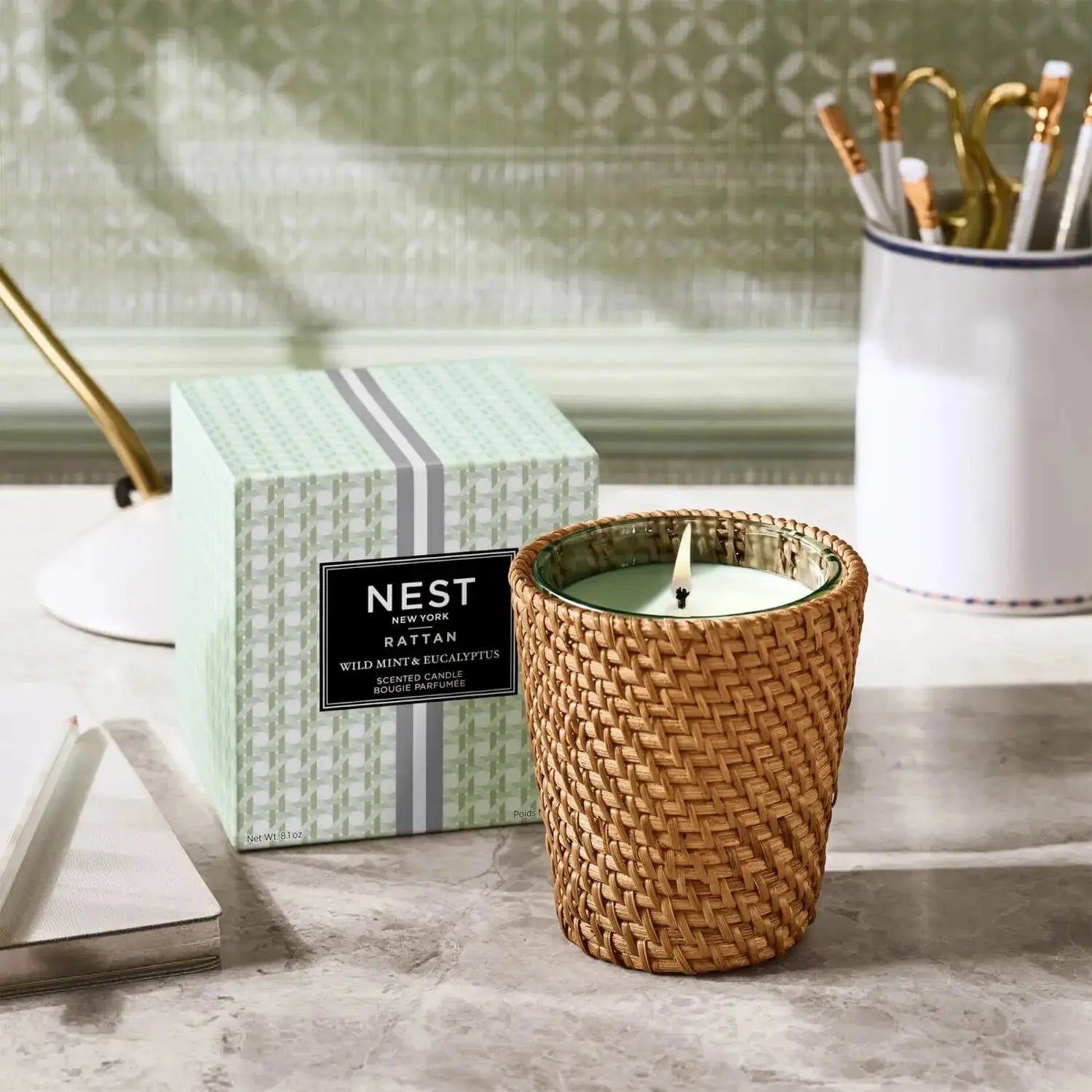 Nest Fragrances Wild Mint and Eucalyptus Rattan Classic 8.1 ounce Candle in a room