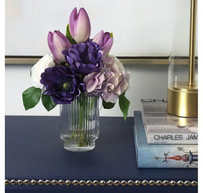 Diane James Purple Hydrangea and Tulip Bouquet on navy blue table set next to a couple of books