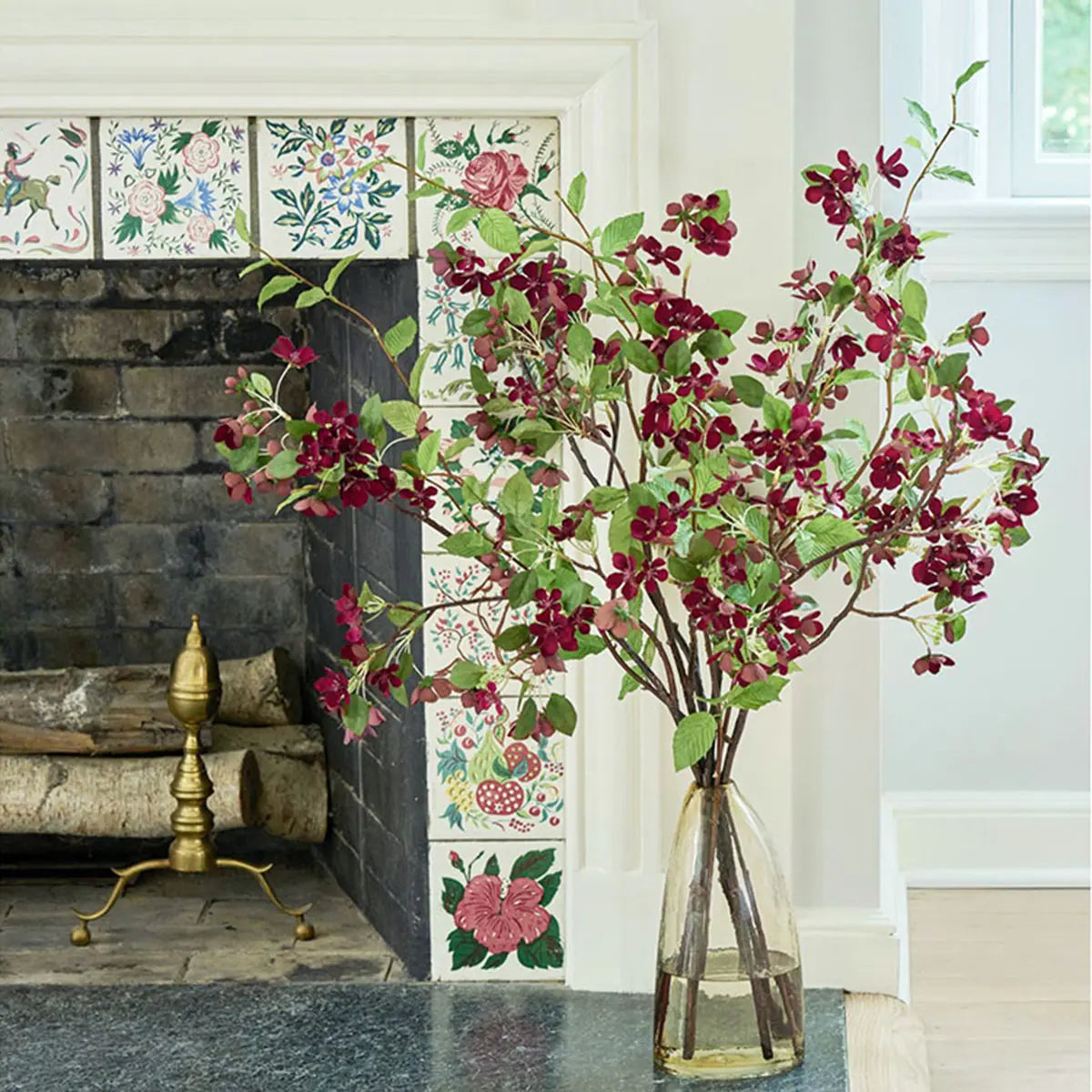 Diane James Burgundy Apply Blossoms on a table by a fireplace
