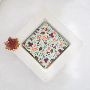 Nora Fleming Napkin holder with fall napkins and a leaf mini