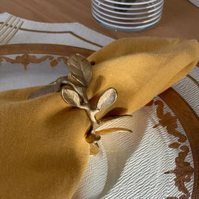 Bodrum Laurel Canyon Crown Napkin ring in Gold on a gold napkin set on a plate